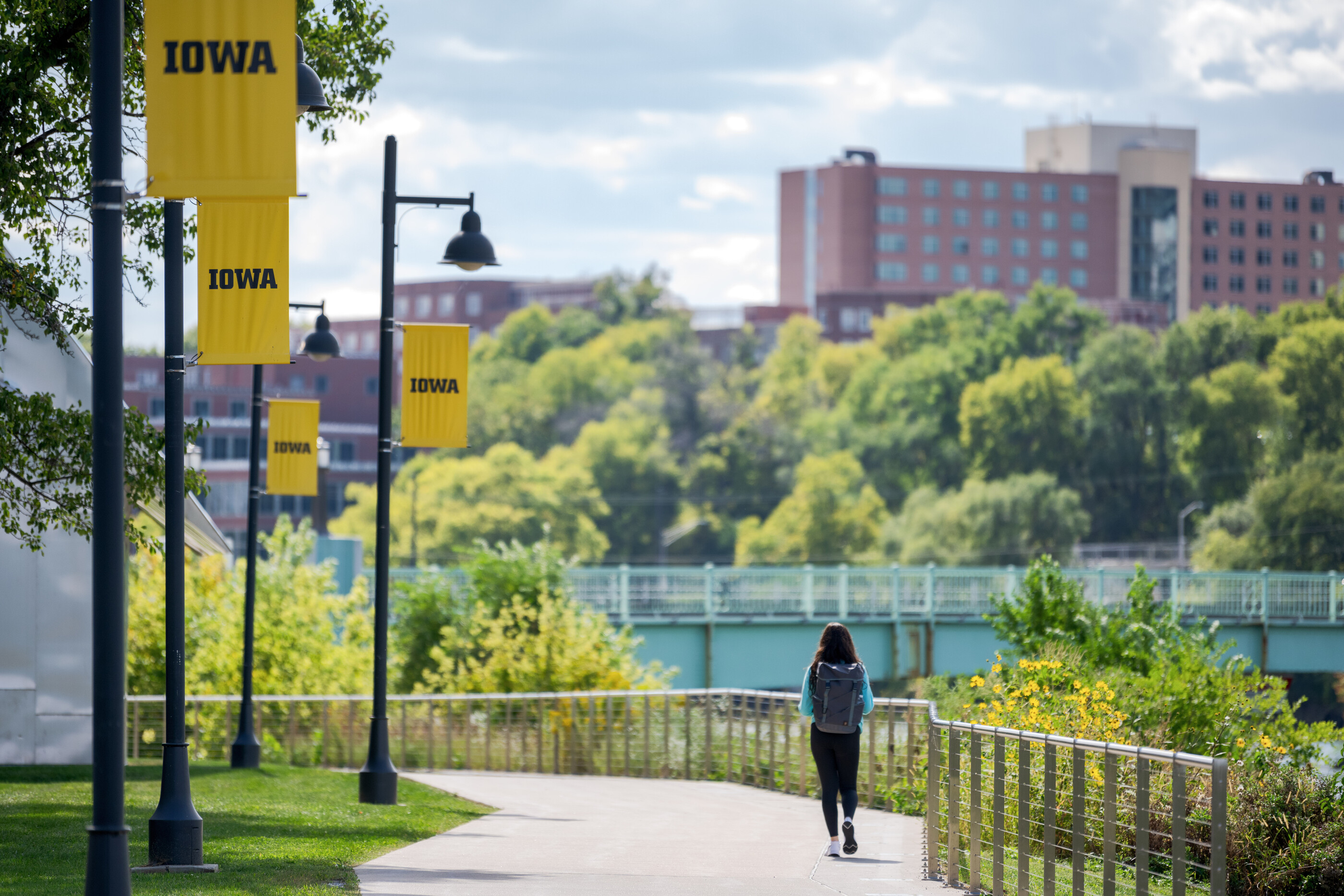 Student walks along the river path