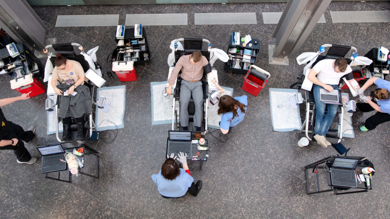 Photo from above of three students donating blood